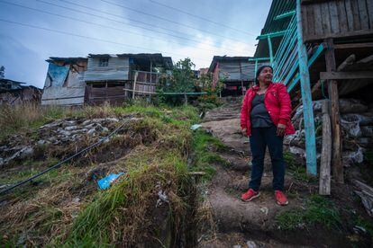 Isleni Pérez posa frente a su casa (de color azul claro). Es madre soltera de cinco hijos y se mudó al barrio luego de perder su trabajo durante la pandemia. 