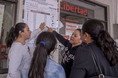 Un grupo de mujeres observa los resultados de votos en una casilla en Atlacomulco.