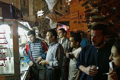 Un grupo de palestinos escucha las noticias de la radio en un puesto del centro de Ramala.