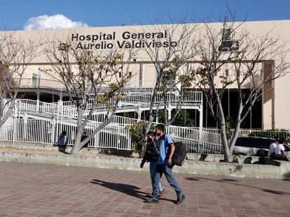 Jóvenes caminan frente al hospital en el que se encontraba hospitalizado el menor, en la Ciudad de Oaxaca.