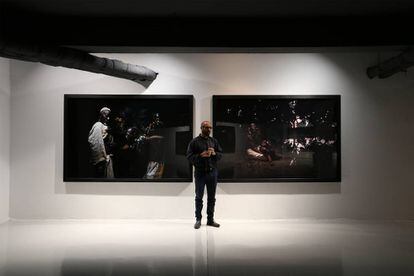 El artista tunecito Wahib Chehata, entre dos de sus obras expuestas en Rabat.