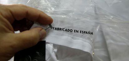 Una trabajadora coloca una etiqueta en una f&aacute;brica textil.