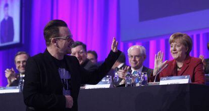 Bono saluda a Merkel y otros pol&iacute;ticos en el congreso del PPE.