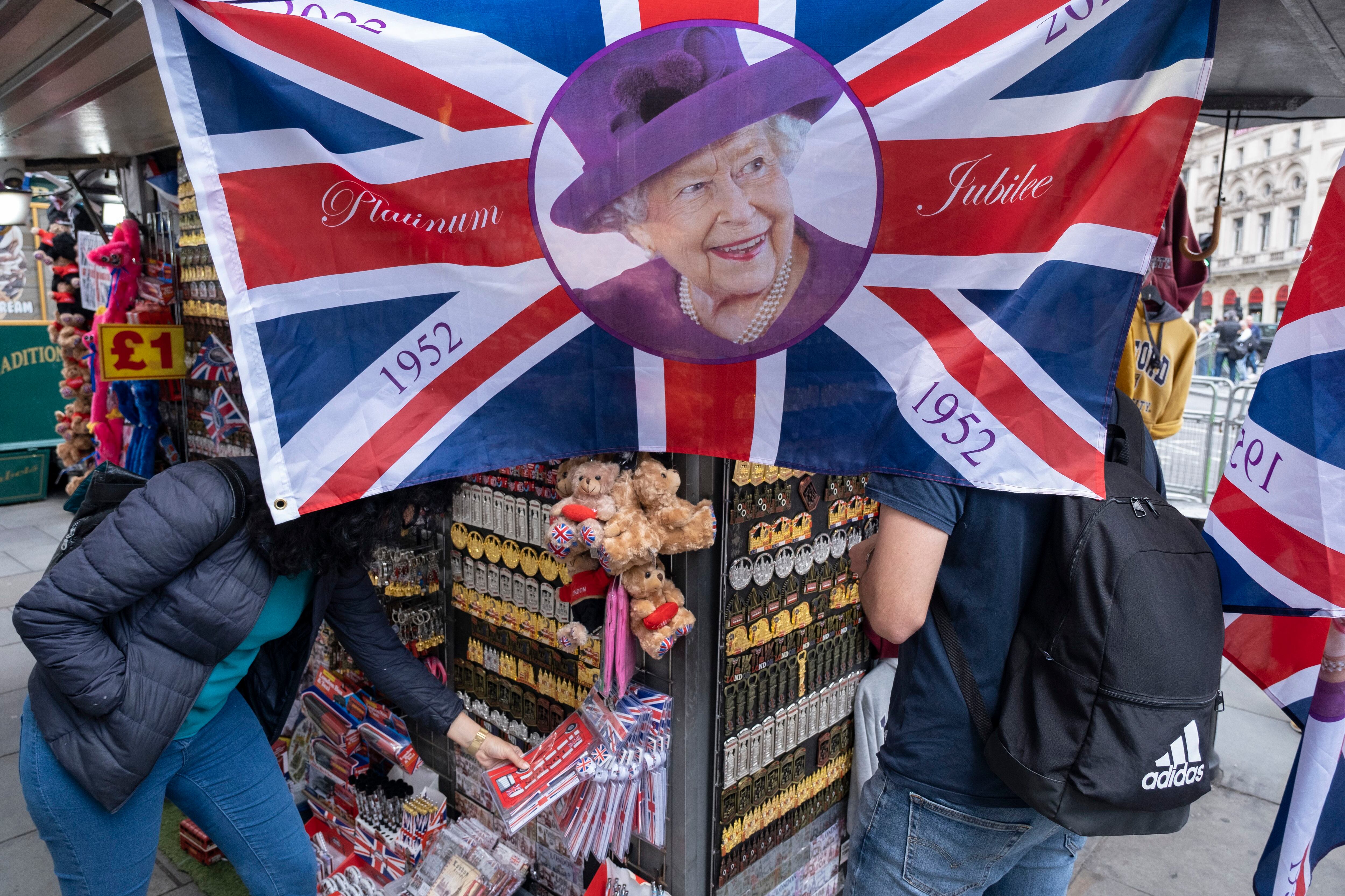 Banderas con la cara de Isabel II, a la venta en un puesto de 'souvenirs' en celebración del Jubileo de Platino, el 1 de junio en Londres.  