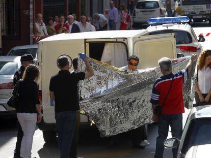 Trabajadores de una funeraria trasladan el cadáver de la mujer, ayer en el barrio bilbaíno de Deusto. 