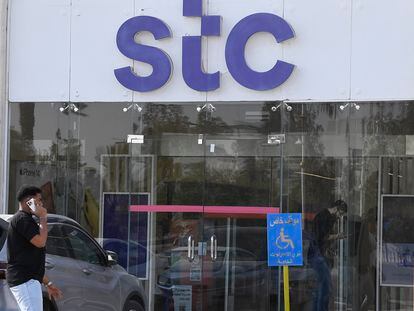 Un hombre habla por teléfono junto a la sede de STC en Riad.