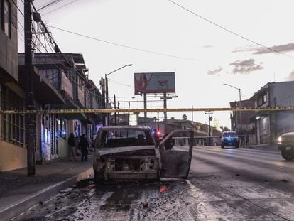 Policías acordonan la zona en donde se halló un vehículo incinerado en Tijuana, Baja California.