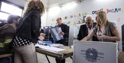 El líder de Forza Italia, Silvio Berlusconi, coge su papeleta para votar en los comicios de Roma.