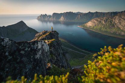 Una mujer contempla el horizonte desde el monte de Husfjell, en la isla de Senja, en Noruega.