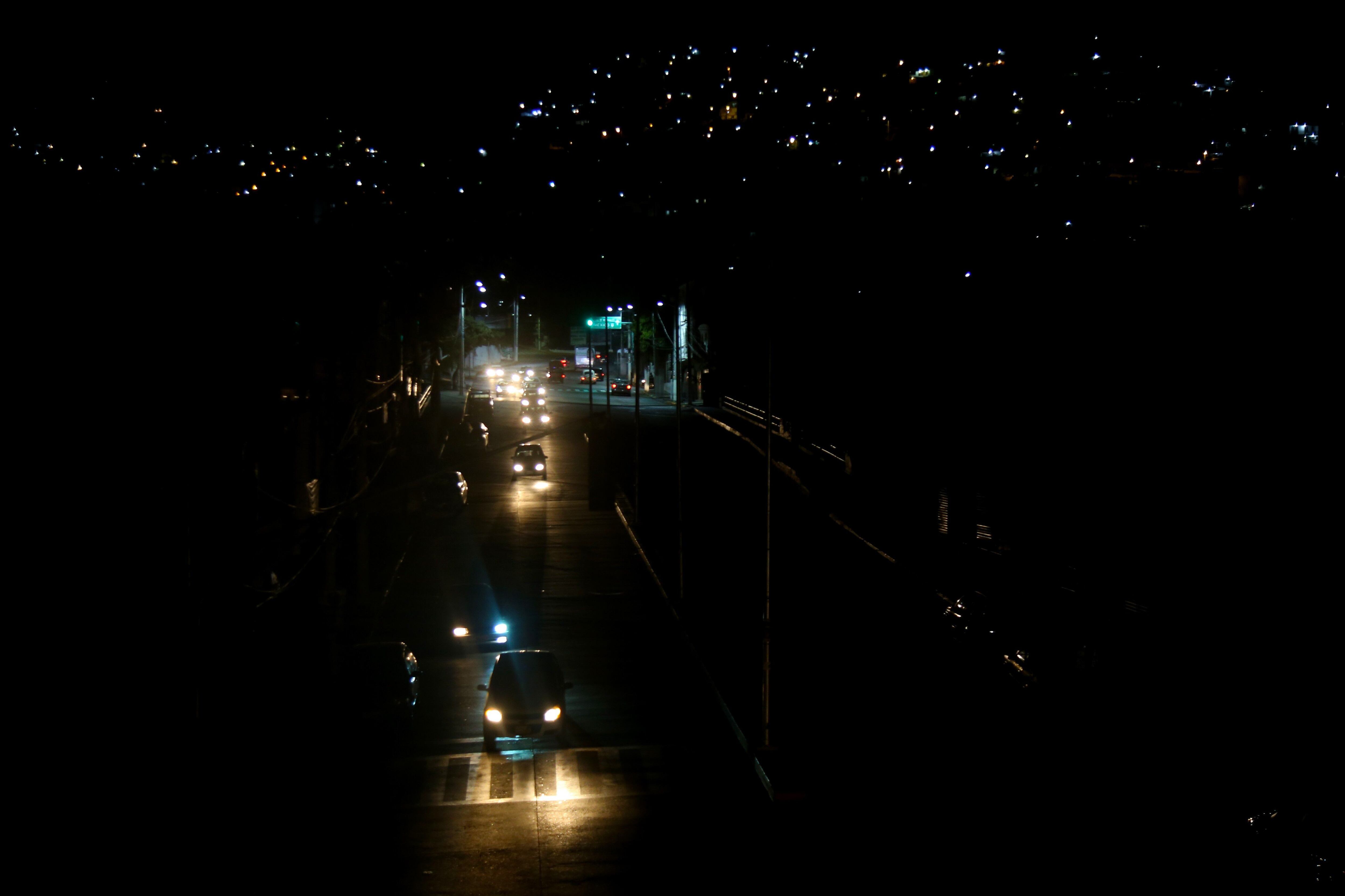 Los carros se abren paso por una calle obscura en una de las colonias de la periferia del Puerto de Acapulco.