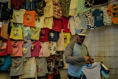 Christopher desmonta el puesto de ropa para bebé. Cuando todos los comerciantes terminan de trabajar, ellos empiezan de nuevo y su puesto se transforma en un local de repostería.