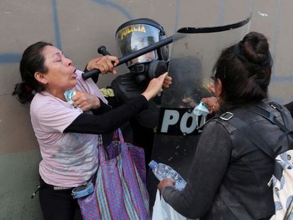 Mujeres manifestantes pelean con un policía antidisturbios durante una protesta que exige la disolución del Congreso y la celebración de elecciones democráticas en Perú.