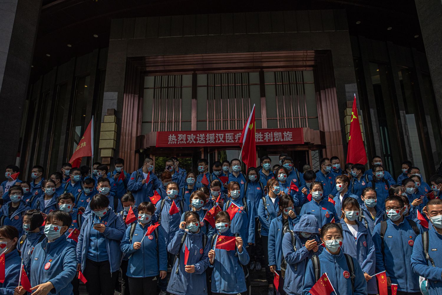 Trabajadores médicos chinos de la provincia de Shandong participan en una ceremonia antes de abandonar Wuhan.