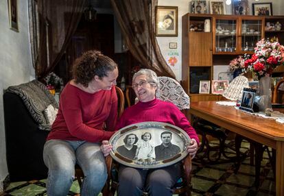 Pepita Barrón y Raquel Canovés, hija y nieta de José, con un montaje fotográfico de Pepita, su madre y su padre, en su casa de Aldaia (Valencia).