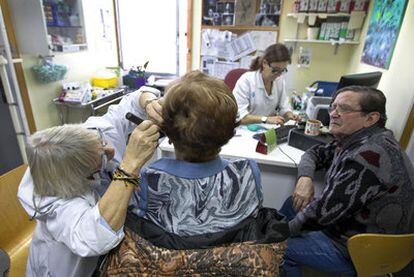 Una médica atiende a dos pacientes en un centro de salud en Ciutat Vella, Barcelona.
