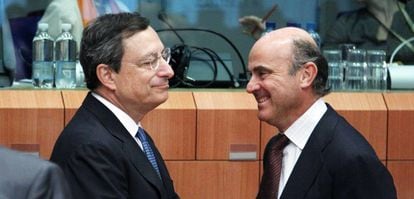 El presidente del BCE, Mario Draghi, junto a Luis de Guindos en una reuni&oacute;n en Bruselas en julio de 2012