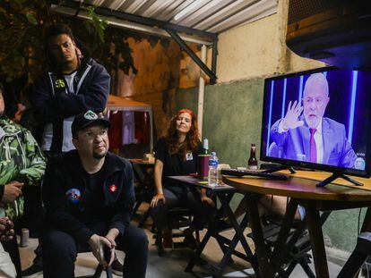 Un grupo de personas se reúne alrededor del televisor para ver la entrevista de Lula, el expresidente y de nuevo candidato presidencial, en el programa de la red Globo, 'Jornal Nacional', este jueves.