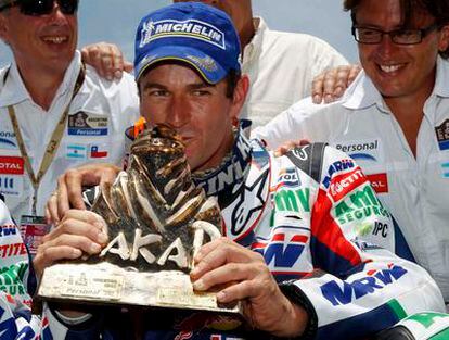 El motorista español, Marc Coma, besa el trofeo que le acredita como ganador en la categoria de motos del Rally Dakar 2011, el tercero de su carrera profesional, durante la ceremonia en Buenos Aires.