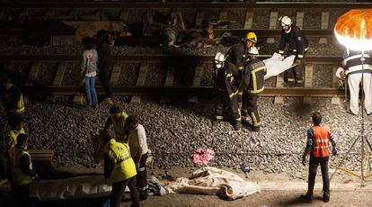 Los servicios de emergencia trabajan junto a las vías tras el accidente del tren Alvia que cubría la ruta entre Madrid y Ferrol y que descarriló anoche cuando ya estaba muy cerca de Santiago de Compostela, 25 de julio de 2013.