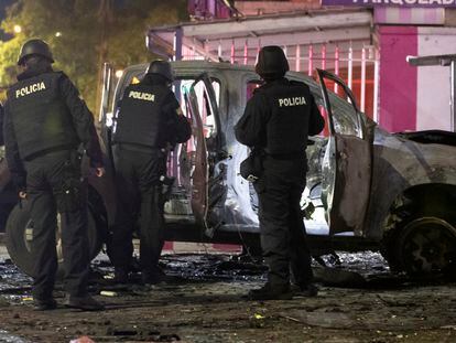 Un grupo de policías junto a los restos de un carro bomba que explotó en los exteriores del edificio del Servicio Nacional de Atención Integral a Personas Privadas de Libertad, en Quito el pasado 31 de agosto.