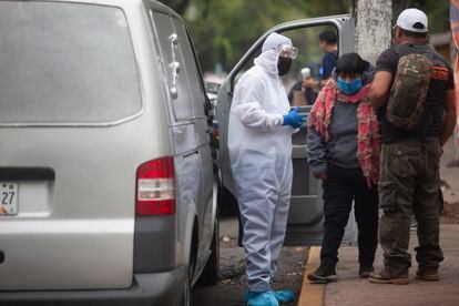 Familiares de un paciente esperan en la puerta del INER la carroza que transportará el cadáver de su familiar, fallecido por coronavirus.