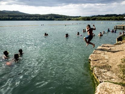 Un niño se lanza al agua del lago de Banyoles, en Girona.
