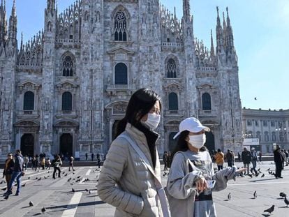 Turistas con mascarilla ante la catedral de Milán, este lunes. En vídeo, las cancelaciones de viajes de estudios a Italia.