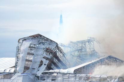 Varias columnas de humo rodean el tejado del edificio incendiado, este martes en Copenhague.