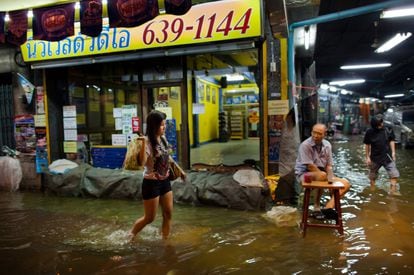 Una chica en una calle inundada del barrio de China town, en Bangkok