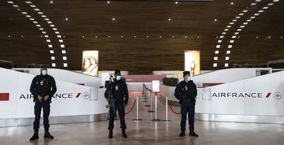 Policía francesa vigila la terminal 2 del aeropuerto parisino Charles de Gaulle, el 14 de marzo de 2020. 
 