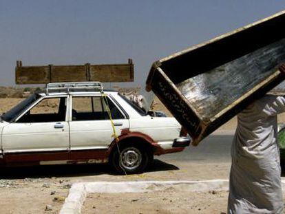 Un hombre transporta un ataúd tras el funeral de una madre y de una hija muertas en un atentado con coche-bomba en Irak en 2003