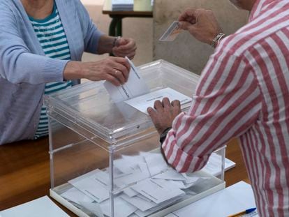 Una persona introduce la papeleta en una urna de un colegio electoral de Sevilla, este domingo.