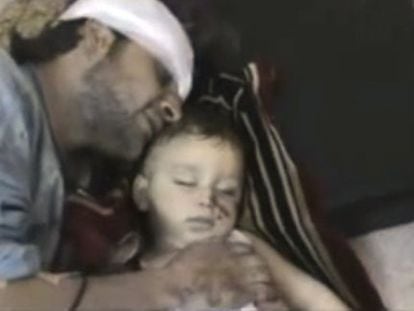 Un hombre herido llora sobre su hijo muerto en Homs.