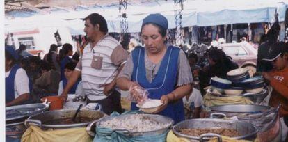 Una mujer regenta un puesto de comida en un mercado de Bolivia gracias a un microcr&eacute;dito. &nbsp;