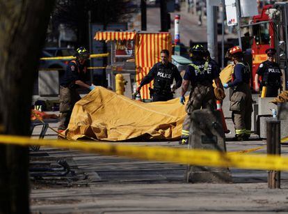 Bomberos y policías cubren a una de las víctimas en los suburbios del norte de Toronto, Canadá.