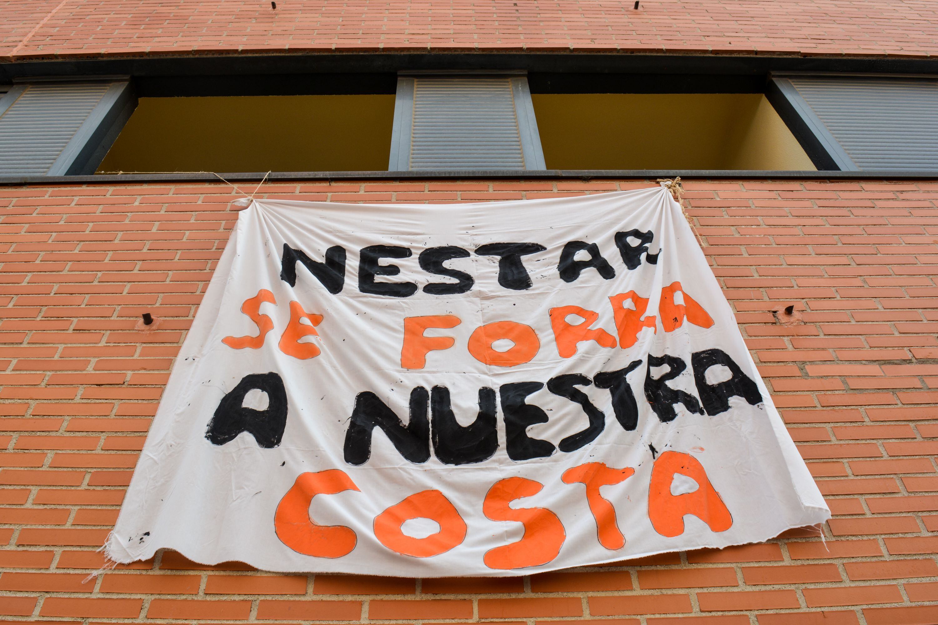 Un cartel improvisado denuncia el estado de abandono de un edificio en Vallecas gestionado por Azora, el tercer mayor tenedor de España.
