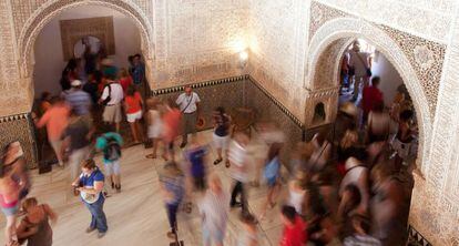 Turistas visitando la Alhambra, en la sala de Dos Hermanas.