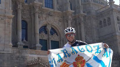 Miguel Cardiel con la bandera del Zaragoza frente a la catedral de Santiago de Compostela tras completar un tramo del Camino de Santiago.