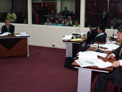 El fiscal Avelino Guillén, a la derecha en primer plano, interroga al ex presidente Fujimori, a la izquierda, sentado al fondo de la sala del juicio.