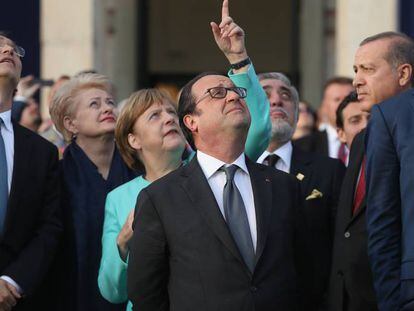 Jens Stoltenberg (izquierda) y varios jefes de Estado y de Gobierno observan las indicaciones de la canciller alemana, Angela Merkel, en la cumbre de la OTAN. 