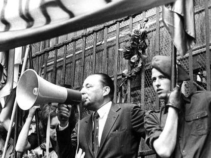 Carlos García Juliá sostiene una bandera en un mitin ultraderechista junto Blas Piñar, líder de Fuerza Nueva.