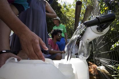 Los residentes llenan contenedores con agua en una fuente de agua de manantial natural en Ciudad del Cabo, Sudáfrica, el jueves 1 de febrero de 2018.