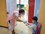 En la imagen, una profesora pone gel desinfectante en las manos a un niño en el colegio Millares Carló de Puerto del Rosario (Fuerteventura).