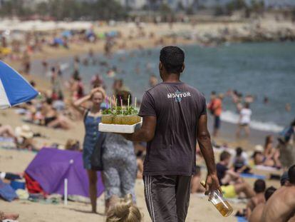 Un vendedor ambulante con una bandeja de mojitos en la Barceloneta.