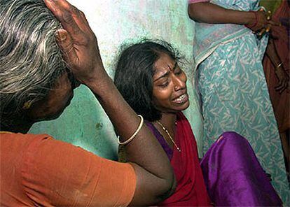 Dos familiares de los niños muertos en el incendio de una escuela de India lloran en el hospital de Kumbakonam.