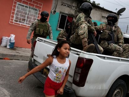 Una niña pasa frente a militares ecuatorianos en la ciudad de Guayaquil, en Ecuador.