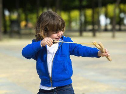 Un niño jugando con un tirachinas