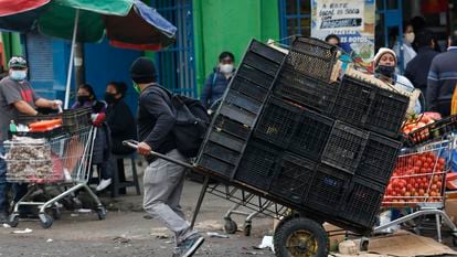 Un hombre jala un carro de carga repleto de cajas vacías, en el Mercado Central de Santiago (Chile), en una imagen de archivo.