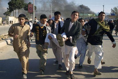 Varios jóvenes trasladan a un hombre herido en el ataque a la sede de Naciones Unidas en Mazar i Sharif.