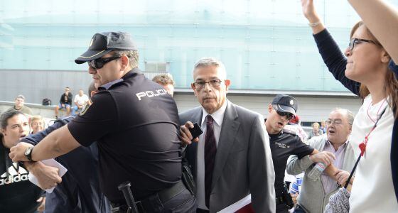Manuel Camilo Hermo Patiño, con traje gris y corbata, entrando en los Juzgados de Pozuelo de Alarcón, entre la protestas de los cooperativistas.